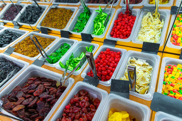 A counter at a healthy food store. Lots of dried fruits and candies made from caramelized and candied fruit