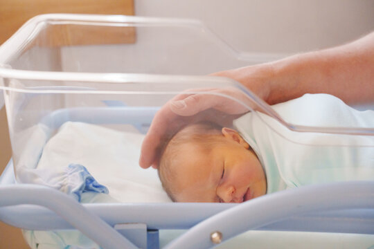Newborn baby resting in a hospital bassinet during day