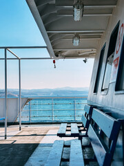 Ferry boat interior deck view with seating and ocean scenery