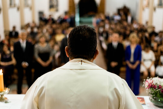 A priest giving a religious ceremony in a church full of worshippers