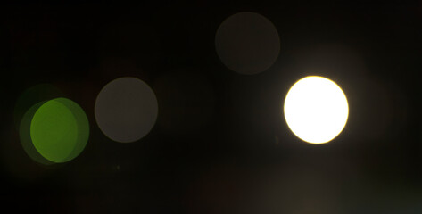 Abstract defocused light circles on dark background used as visual backdrop. Soft blur texture.