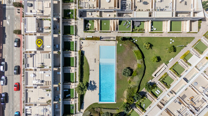 Aerial top-down view of modern apartment complex with swimming pool and landscaped gardens © Tom