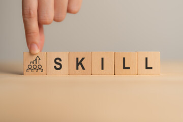 Upskilling and skill development growth. Wooden blocks spell SKILL with an icon showing people and upward arrow. Upskilling, teamwork, personal development and collective growth toward new competency.