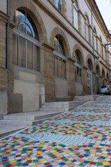 A vibrant mosaic pathway invites visitors in Mont de Marsan. The colorful design contrasts beautifully with the historic stone buildings, adding charm and creativity to the cityscape.