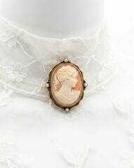 Hyper-realistic animation vintage cameo brooch pinned on white lace collar macro