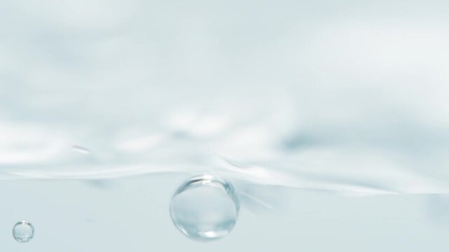 Close up of edge of trembling water surface with bubbles. Scientific background with liquid.