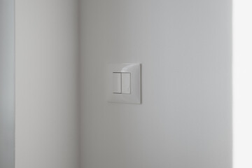 Close-up of a sleek white double rocker light switch mounted on a smooth light-gray wall.