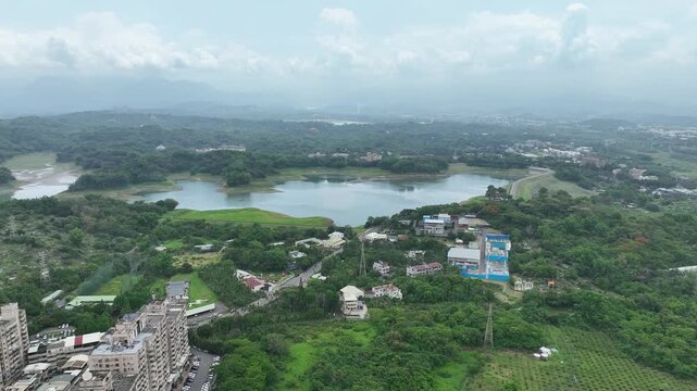 Aerial view of Lantan Reservoir and water treatment plant in Chiayi, Taiwan. Scenic lake landscape with water purification infrastructure and mountain background. 4K Drone