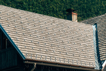 Alpine house roof with snow guards and protective metal stoppers for winter snow safety.