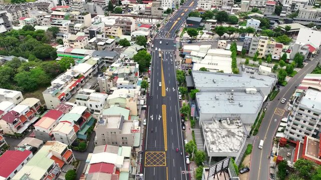 Aerial view of wide urban avenue and city skyline with mountain range background in Taiwan, Chiayi.