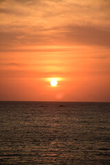 Fototapeta premium Breathtaking tropical seascape at golden hour/sunset, with sunlight reflecting on the calm ocean surface. Ideal for travel, background, and tranquility themes