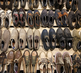 Wide angle shot of numerous pre-owned, vintage, and modern footwear, including many styles