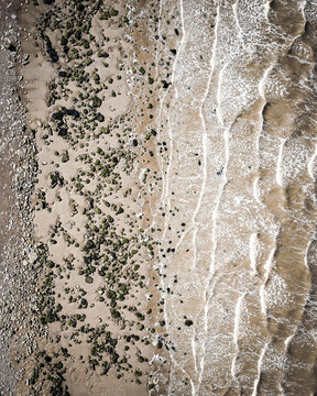 Aerial view of the meeting point of sandy beach and gentle waves, the coast of Camber Sands, Camber Sands, England, United Kingdom.