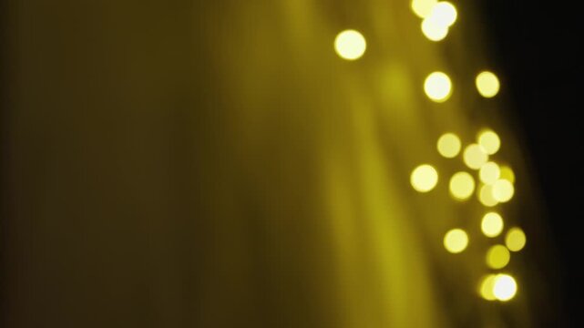 Defocused golden bokeh lights creating a warm festive atmosphere. Abstract background with soft glowing circles, shallow depth of field and copy space. Perfect for holidays, celebrations and elegant v