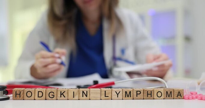 Text Hodgkin Lymphoma on wooden cubes near stethoscope and pills in hospital. Female doctor checks medical records for lymph nodes oncology in patient