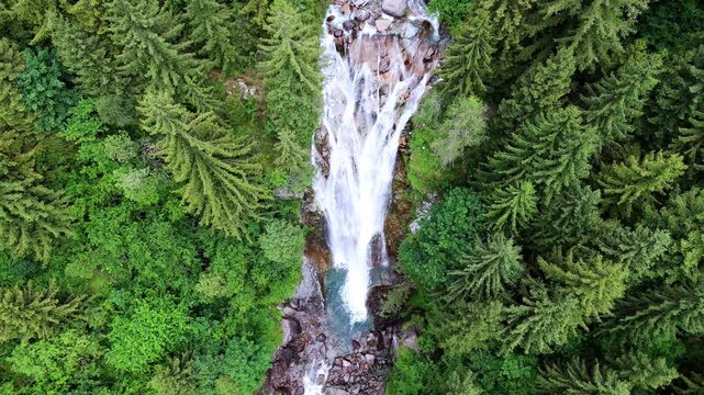 Aerial drone view of V&ograve; Waterfall in Val di Scalve, Italian Dolomites and Alpi Orobie, surrounded by lush alpine pine forests and dense mountain vegetation
