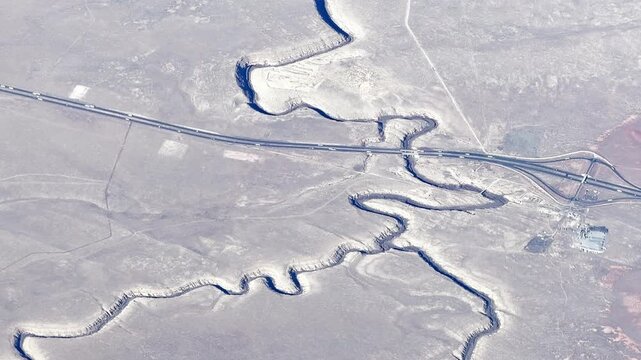 Aerial view capturing the Rio Grande Gorge Bridge and surrounding canyon from an airplane window showcasing scenic landscape and architecture.