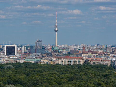 Aerial view of the Fernsehturm piercing the skyline, framed by the lush Tiergarten, a vibrant tapestry of urban life unfolds, Berlin, Berlin, Germany.