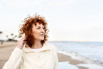 Senior woman looking at the sea during a peaceful beach walk