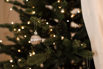 Christmas decorations with glowing lights on xmas tree close up. Winter holiday season celebration.