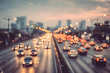 Blurred evening city traffic with glowing tail lights creating vibrant bokeh effect on a busy multi-lane highway under a moody cloudy sky