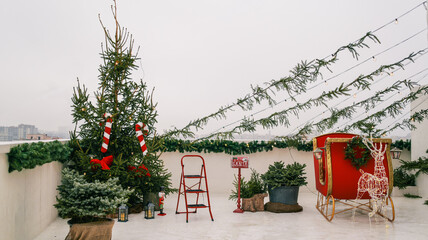 Festive rooftop Christmas decoration with a sleigh, tree, and reindeer lights