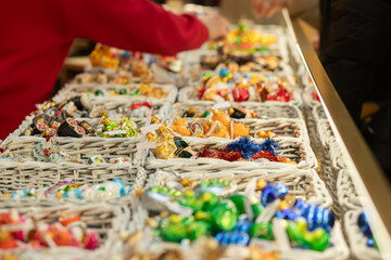 Christmas tree decorations toys on Christmas market, gold and blue ornaments in a festive winter market, celebrating the joy of December traditions.