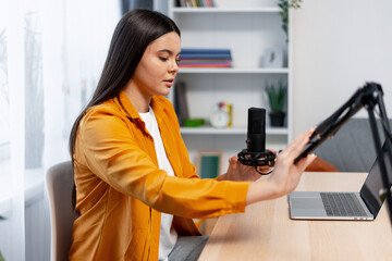 Woman recording audio content for a podcast, streaming from her home studio setup. - 82 characters -