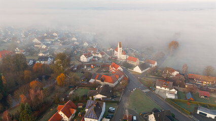 Foggy Bavarian landscape during morning sunrise phase with forest background and small village close which is called P&ouml;rnbach and is located at the region of Pfaffenhofen