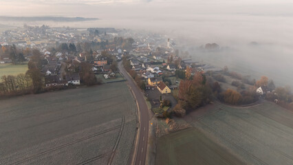 Foggy Bavarian landscape during morning sunrise phase with forest background and small village close which is called P&ouml;rnbach and is located at the region of Pfaffenhofen
