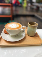 cup of coffee with some cookies on the tray