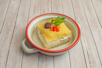 Classic causa  presented in layers of smooth yellow potato purée seasoned with aji amarillo, filled with flaked tuna and mayonnaise, and garnished with hard-boiled egg, olives, and fresh parsley.