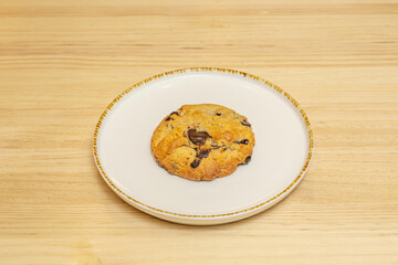 Double chocolate chip cookie with dark and white chocolate chips, featuring a soft, almost melted center, presented on a marble plate