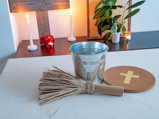 Christian altar with wooden cross, candles and holy water and aspergillum in minimal interior