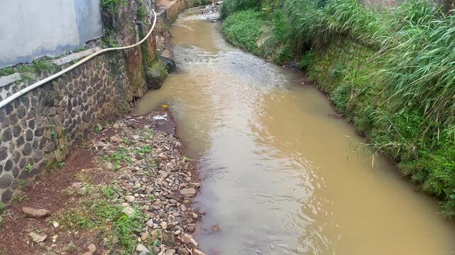 High angle view of a large drainage ditch and water canal in an open field during the day