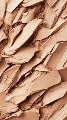 Powder foundation texture with fragmented pieces and fine dust in warm beige tones.