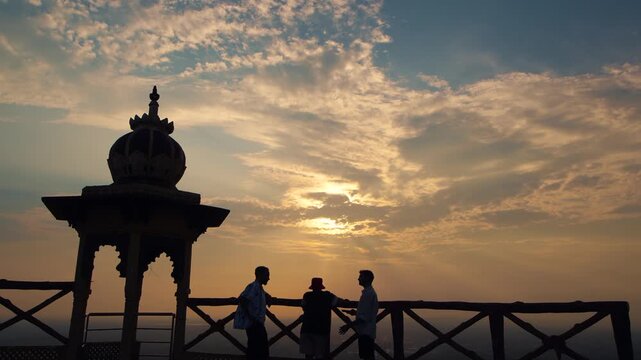 Silhouettes of people helping each other on top of a mountain at Samai Mata Mandir, Banswara, near Udaipur, Rajasthan, India.