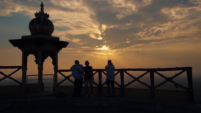 Silhouettes of people helping each other on top of a mountain at Samai Mata Mandir, Banswara, near Udaipur, Rajasthan, India.