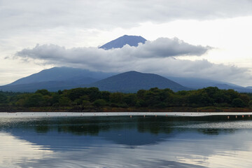 Mount Fuji reflected in still lake water at dawn