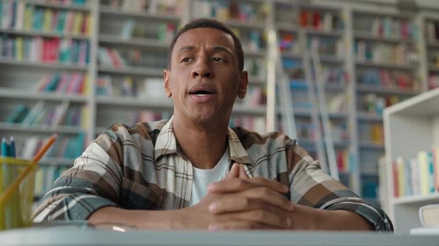 Stressed African American man student in library massaging head headache eyes closed migraine guy tired male studying exam pressure learning fatigue struggle motivation challenge concentration problem