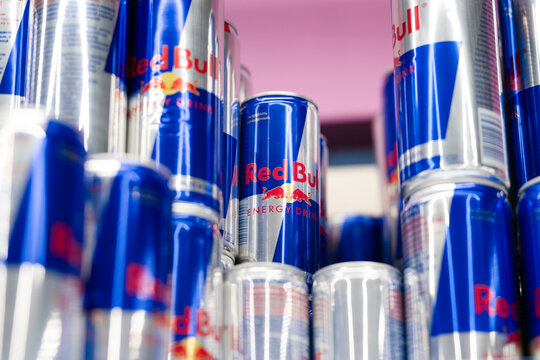 Vladikavkaz ,Russia - December 15 , 2025 : Multiple red bull energy drink cans stacked on a supermarket shelf . Red Bull is an energy drink sold by Austrian company Red Bull GmbH, created in 1987.