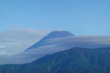 Fototapeta premium Mount Fuji rising above coastal Japanese city harbor