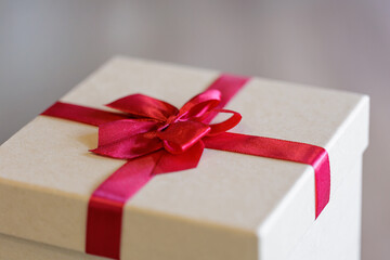 Close-up of Vibrant Red Satin Bow on Elegant White Gift Box, Luxurious Holiday Packaging