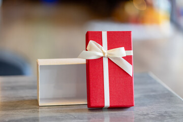 Open Red and White Gift Box with Bow on Table, Ready for Unboxing or Product Placement Mockup