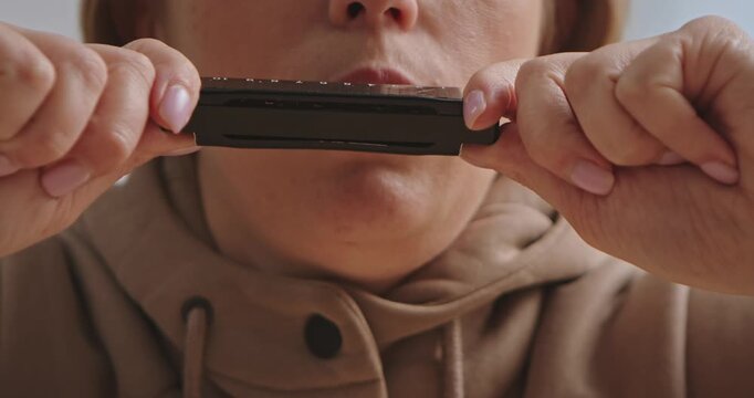 Close Up of Person Playing Harmonica with Focused Expression