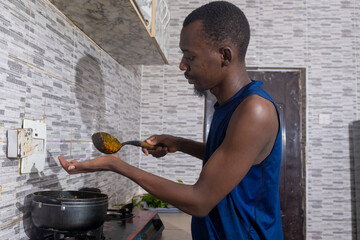 Man tasting his dish while cooking to ensure perfect seasoning.