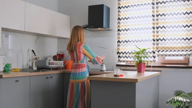 caucasian woman organizing kitchen essentials, woman pauses while preparing items on kitchen countertop, woman of caucasian ethnicity taking pause while arranging various items on kitchen counter