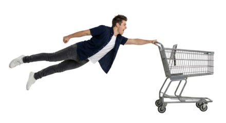 Dynamic young man pushing shopping cart in mid-air isolated on backdrop