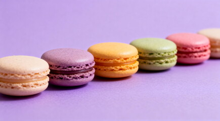 Obraz premium Colorful macarons arranged in a row on a purple background