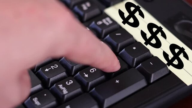 Un primer plano de un teclado con n&uacute;meros con el dedo de una mujer adulta marcando los n&uacute;meros y una nota amarilla con el s&iacute;mbolo de dinero